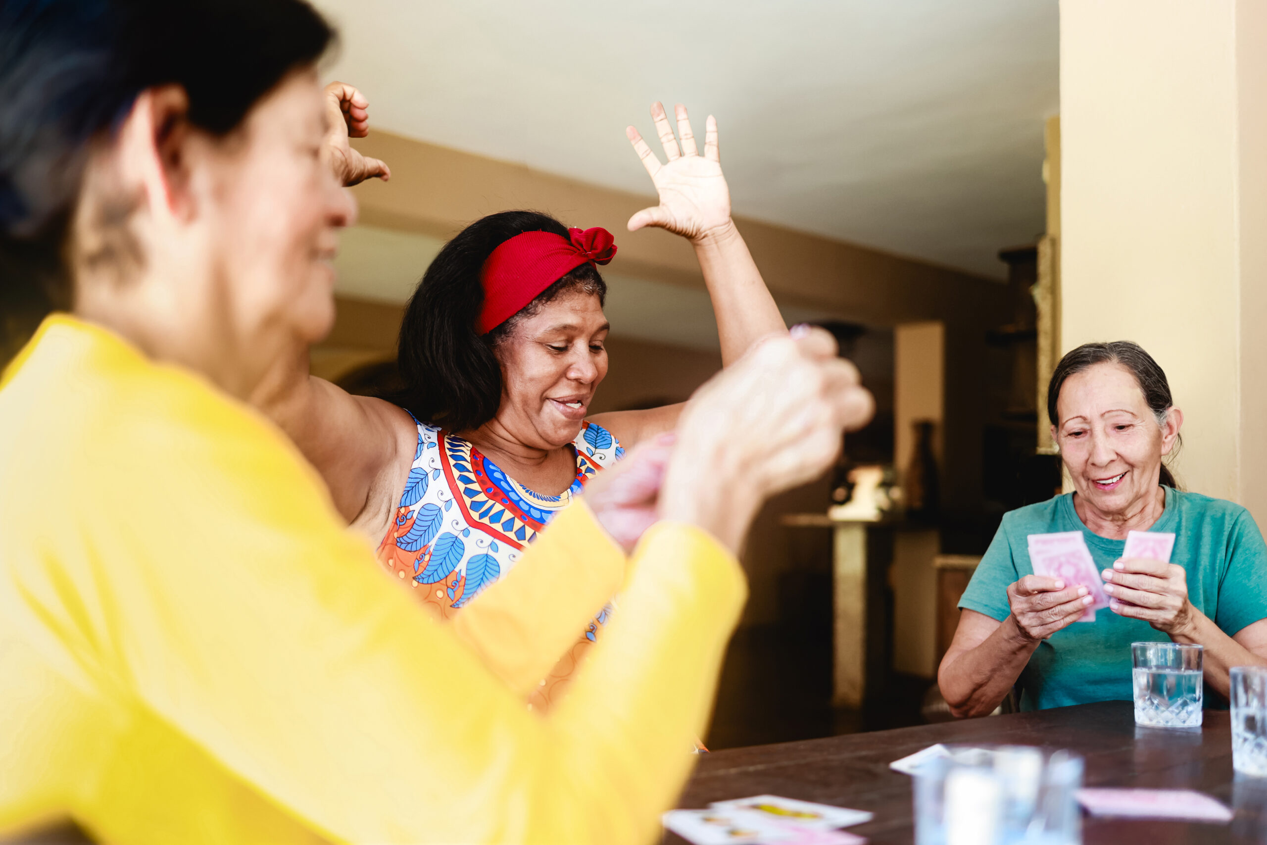 Women playing cards in assisted living studio apartments.