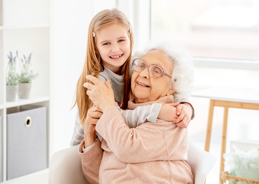 Grandmother with granddaughter visiting her in her memory care apartments