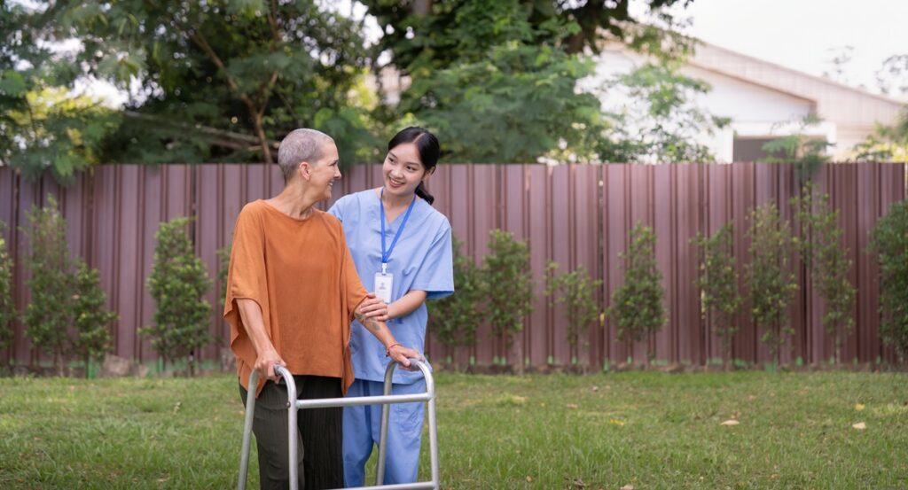 Assisted living community walking path with handrails, even flooring and good lighting to support safe mobility